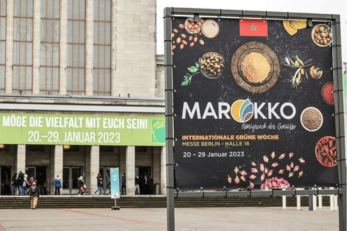 Zu sehen ist der Eingang Messe Nord und ein großer Werbeaufsteller in der rechten, vorderen Ecke.