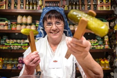 A woman is holding two pickles.