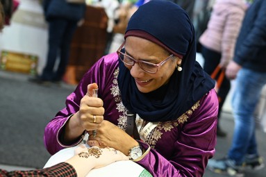 Eine Frau, die eine Hand mit 'Henna' bemalt
